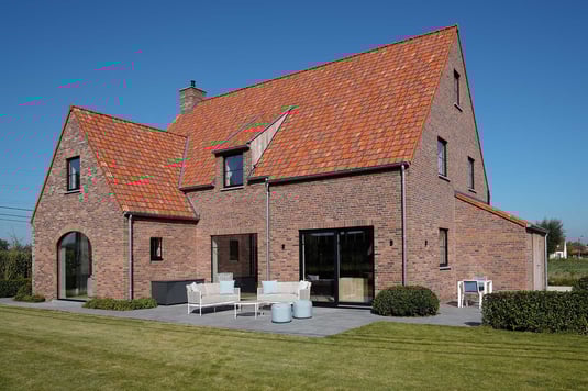 Landelijke villa met rode baksteengevel en modern raamwerk